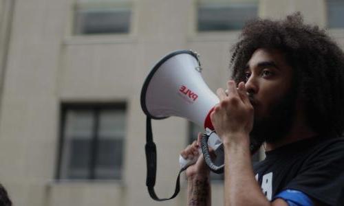 Young protester holds megaphone.